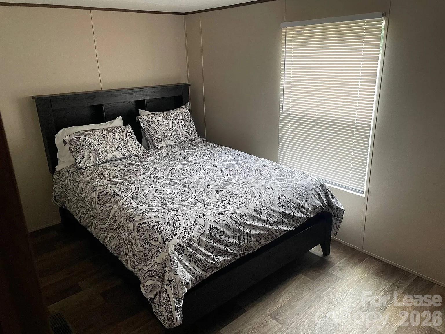 3298 Pea Ridge Road Mill Spring, NC 28756 - Photo 7 of 7 a bed sitting in a bedroom next to a window