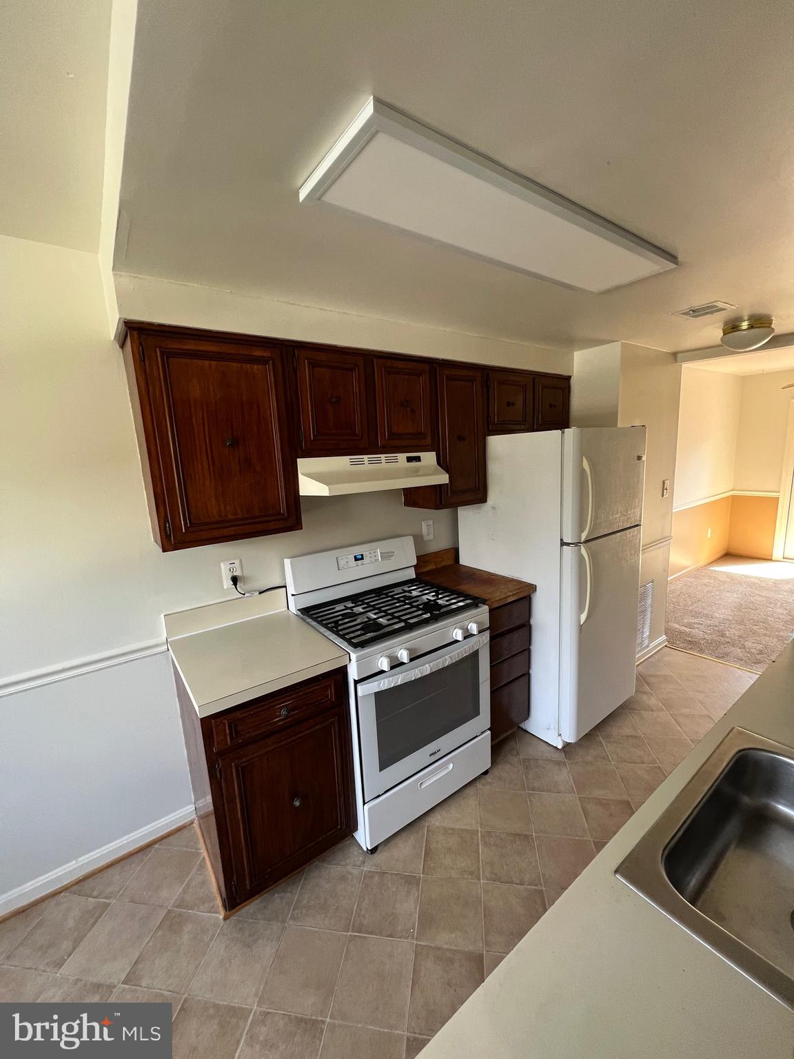 5805 Morningbird Lane Columbia, MD 21045 - Photo 5 of 26 a kitchen with stainless steel appliances granite countertop a stove a refrigerator and a microwave