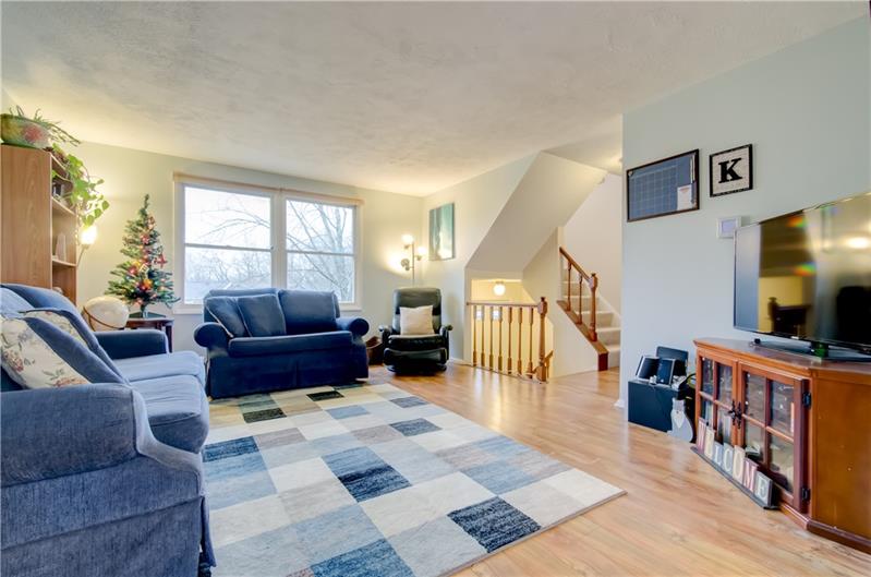 222 Quail Run Road Venetia, PA 15367 - Photo 7 of 22 Living room with large window that provides lots of natural light. Beautiful wood toned laminate flooring throughout the first floor. Powder room and large closet located at top of main floor stairs.