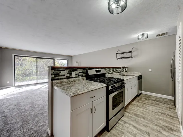 a kitchen with stainless steel appliances granite countertop a stove and a sink