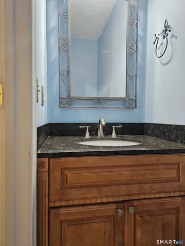 a bathroom with a granite countertop sink and a mirror
