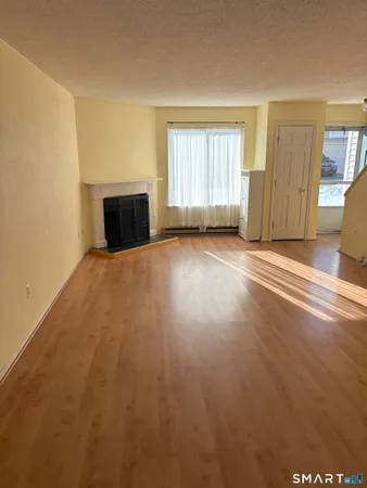 an empty room with windows and fireplace