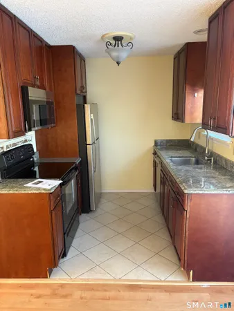 a kitchen with stainless steel appliances granite countertop a stove a refrigerator and a sink