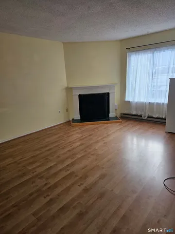 a view of an empty room with a fireplace and a window
