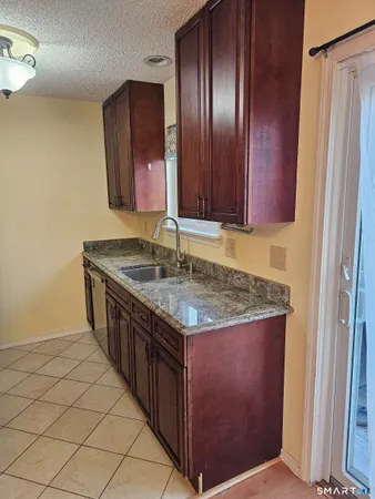 a kitchen with granite countertop a sink stove and cabinets