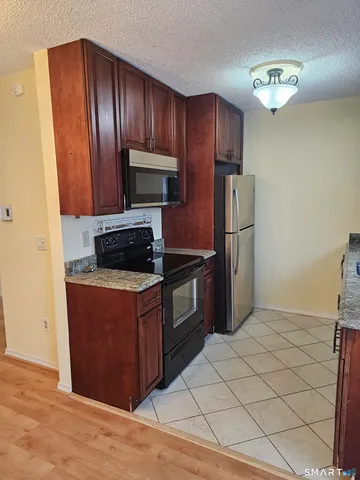 a kitchen with stainless steel appliances granite countertop a refrigerator stove and microwave