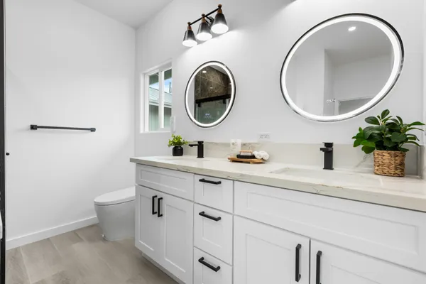 a bathroom with a granite countertop toilet sink and mirror