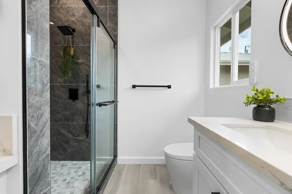 a bathroom with a sink a toilet and shower