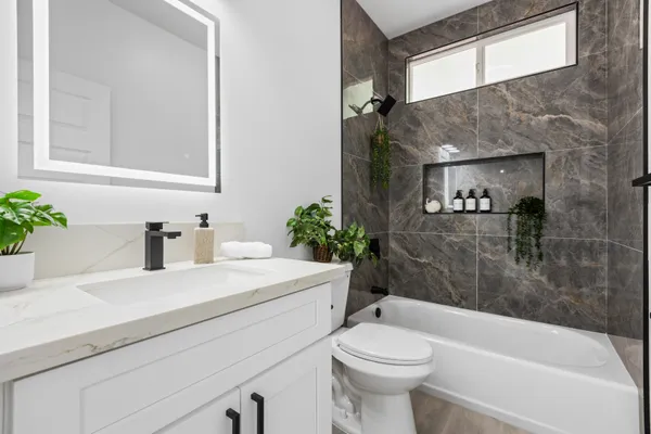 a bathroom with a sink a toilet and shower