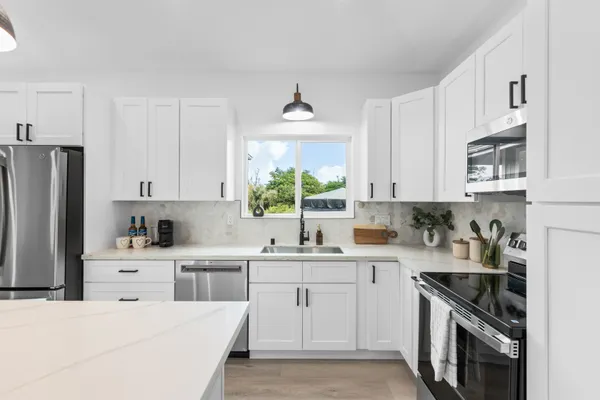 a kitchen with a sink stove and refrigerator