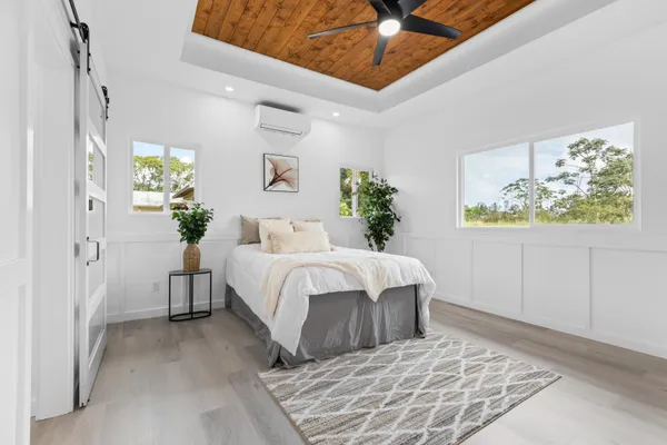 a bedroom with a large bed and a chandelier