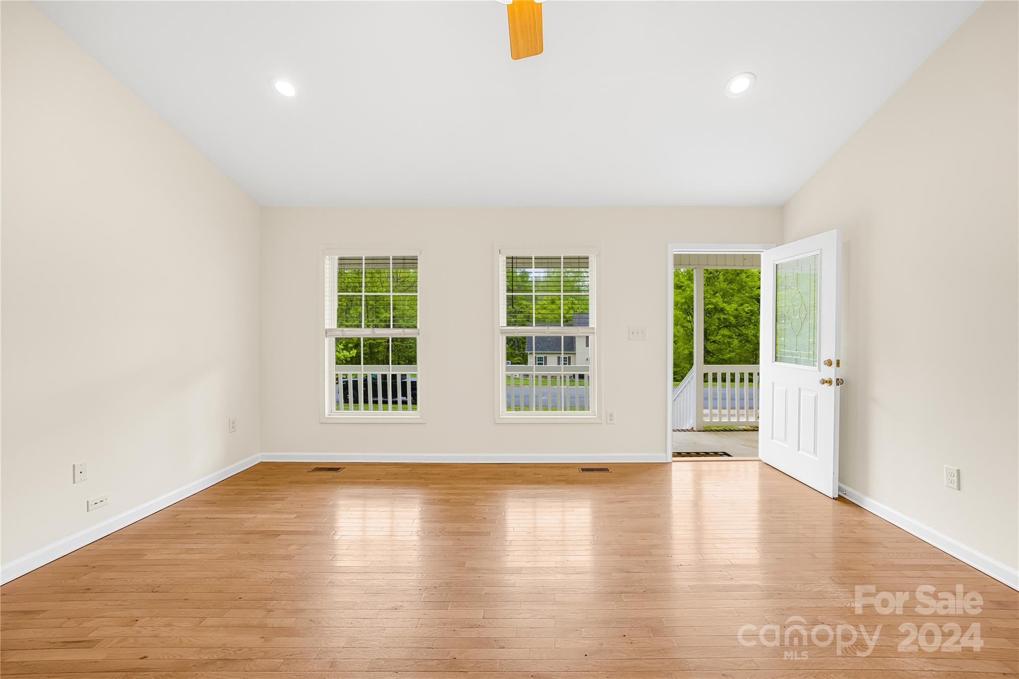 220 Shenandoah Loop Troutman, NC 28166 - Photo 6 of 26 an empty room with wooden floor and windows