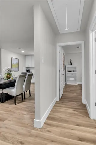 a view of a hallway with wooden floor and furniture