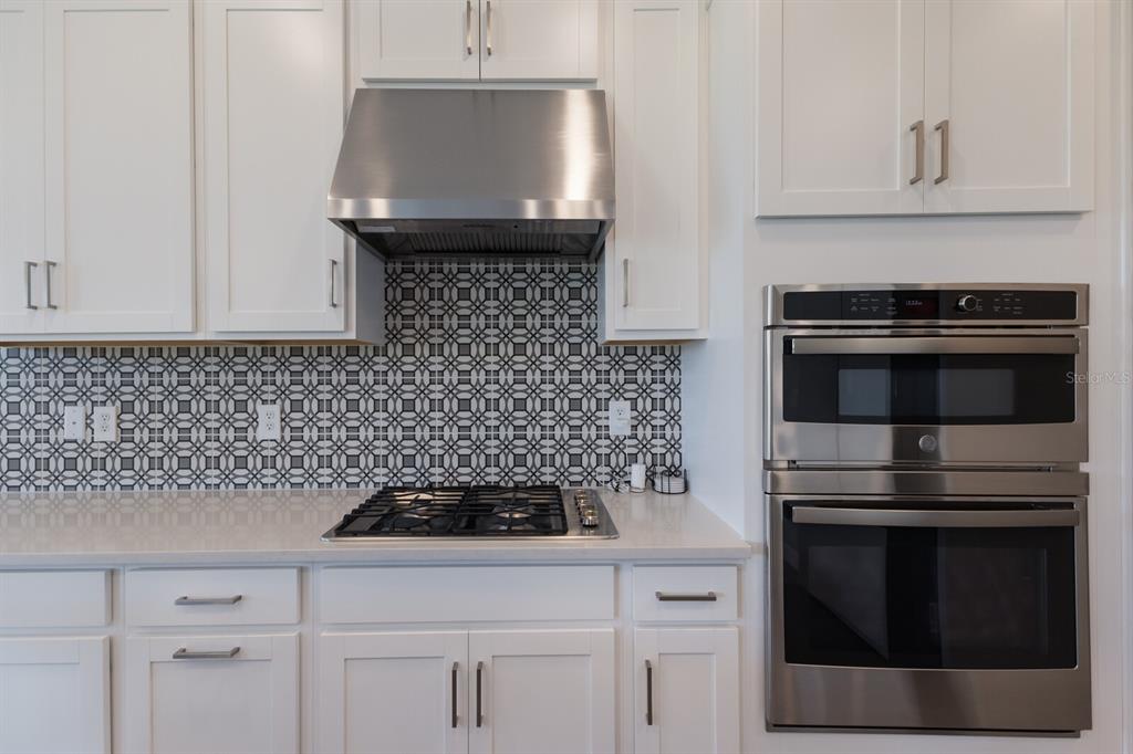 9312 Tequila Sunrise Drive Sarasota, FL 34241 - Photo 14 of 78 a kitchen with a stove and white cabinets