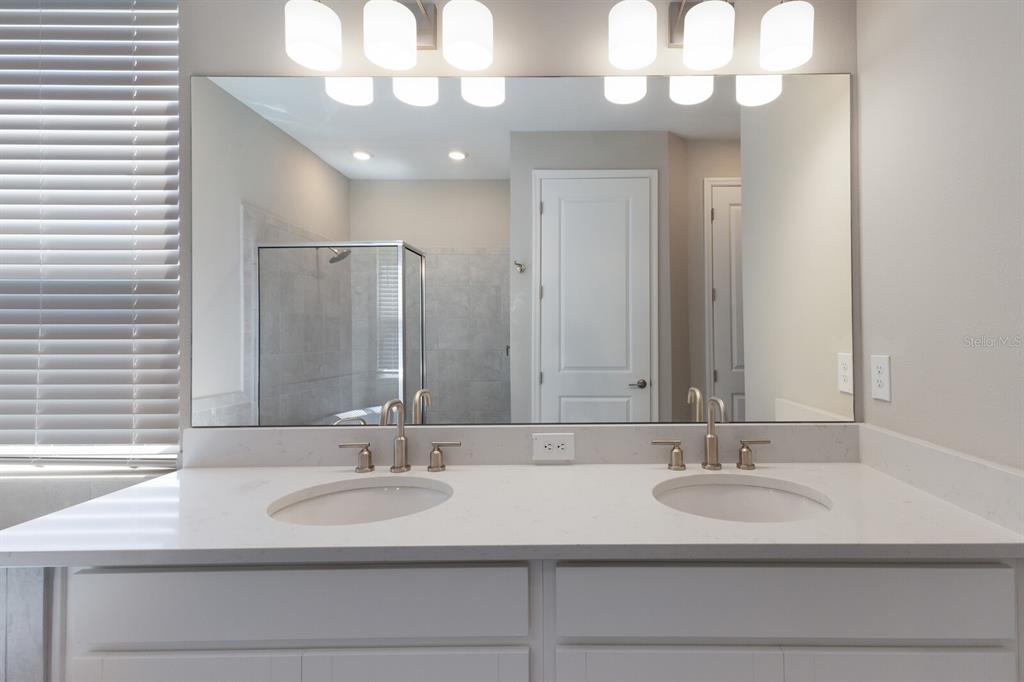 9312 Tequila Sunrise Drive Sarasota, FL 34241 - Photo 21 of 78 a bathroom with a sink a large mirror and a light fixture