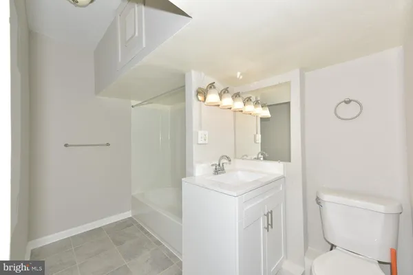 a bathroom with a sink a toilet a mirror and shower