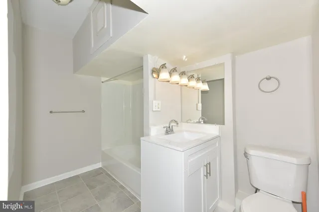 a bathroom with a sink a toilet a mirror and shower