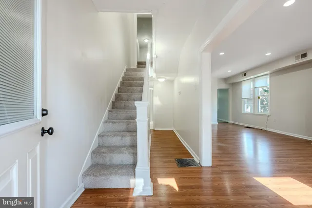 a view of a hallway with wooden floor and staircase