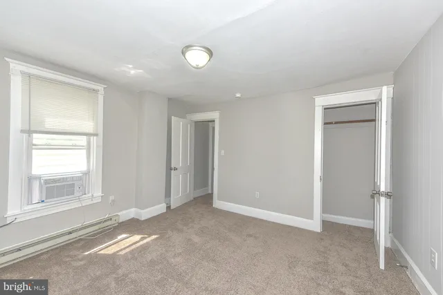 an empty room with windows and closet