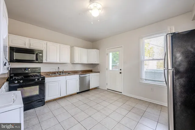 a large kitchen with a stove a sink dishwasher and a refrigerator