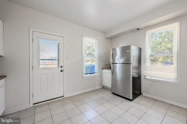 a view of a refrigerator in kitchen and a window