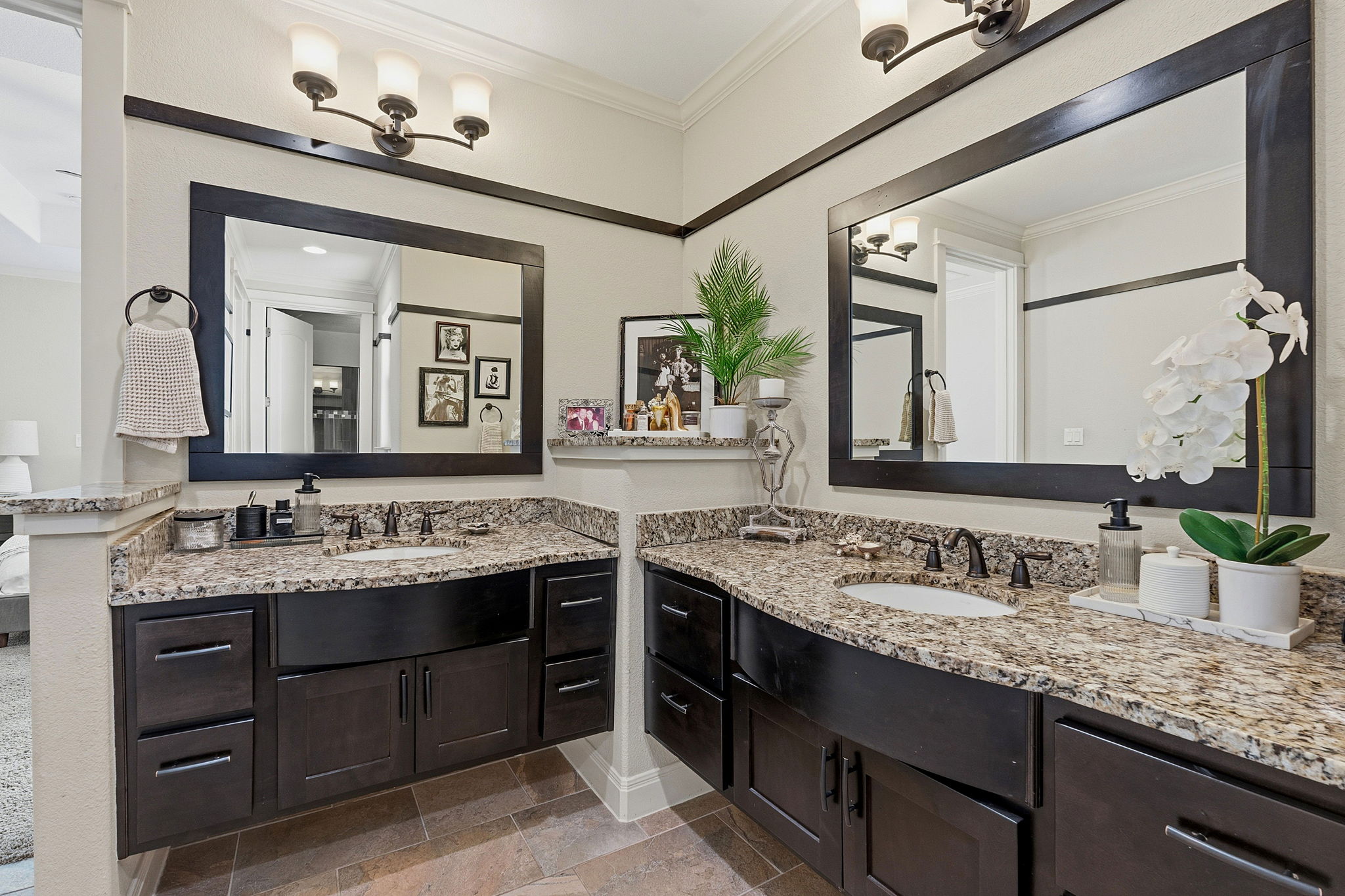 15317 Falconhead Grove Loop Austin, TX 78738 - Photo 5 of 36 Dual vanity with granite countertops, integrated sinks, dark wood-finish cabinetry, and framed mirrors, complemented by dark bronze light fixtures
