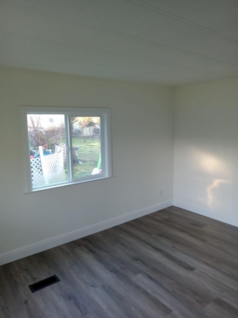 44 The Trees Drive, Unit 44 Concord, CA 94518 - Photo 13 of 22 an empty room with wooden floor and windows