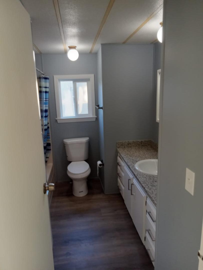 44 The Trees Drive, Unit 44 Concord, CA 94518 - Photo 14 of 22 a bathroom with a granite countertop toilet a sink and a mirror