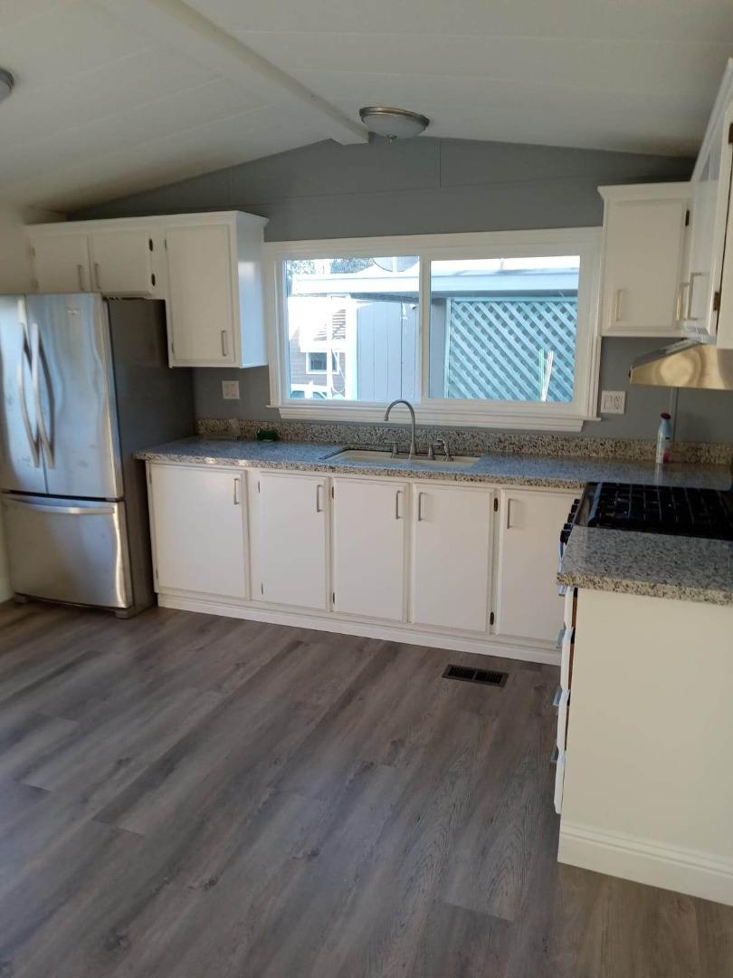 44 The Trees Drive, Unit 44 Concord, CA 94518 - Photo 7 of 22 a kitchen with granite countertop a sink a stove and cabinets