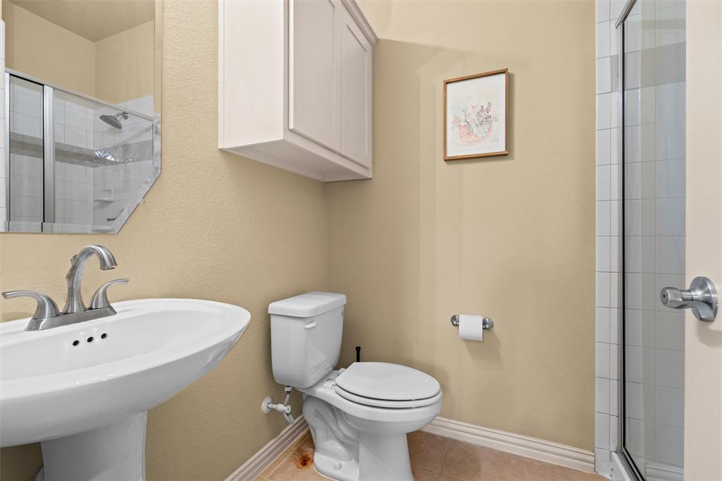 2803 Pino Grand Prairie, TX 75054 - Photo 15 of 36 a bathroom with a sink a toilet and a mirror