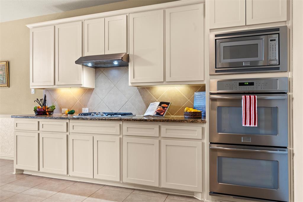 2803 Pino Grand Prairie, TX 75054 - Photo 8 of 36 a kitchen with granite countertop white cabinets and stainless steel appliances