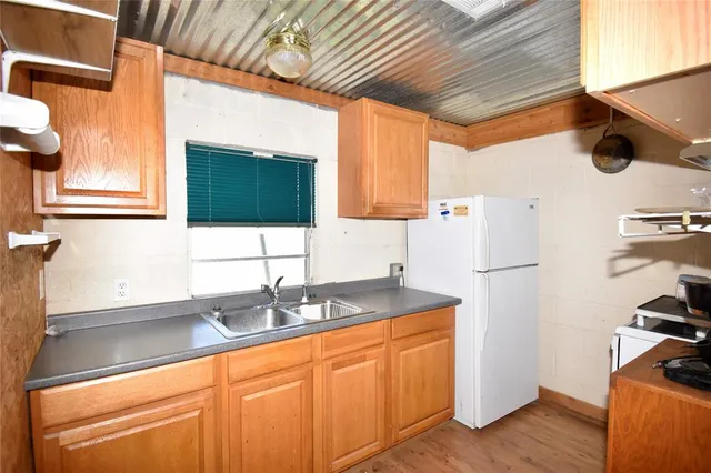 a kitchen with stainless steel appliances granite countertop a sink a refrigerator and a stove