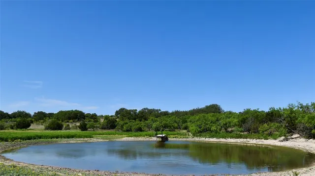 a view of a lake and green valley