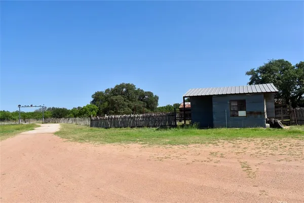 a view of a house with a yard and a large tree