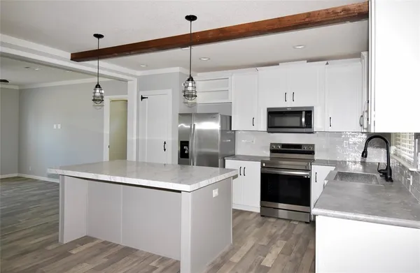 a kitchen with stainless steel appliances a refrigerator sink and microwave