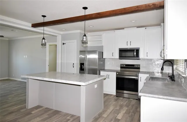a kitchen with stainless steel appliances a refrigerator sink and microwave