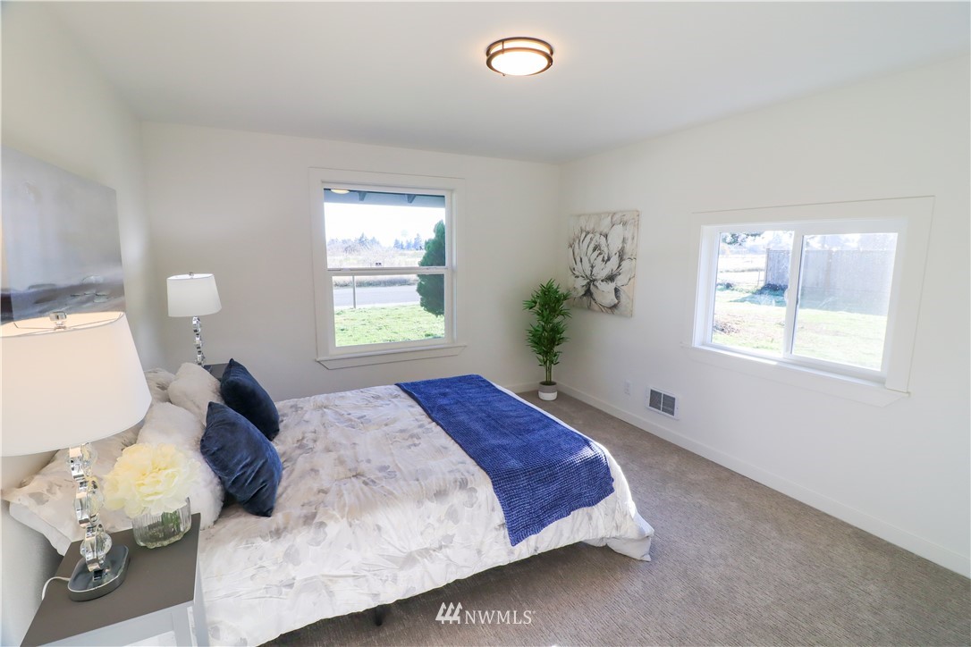 9331 Cullens Road Southeast Yelm, WA 98597 - Photo 13 of 28 a bed sitting in a bedroom next to a window