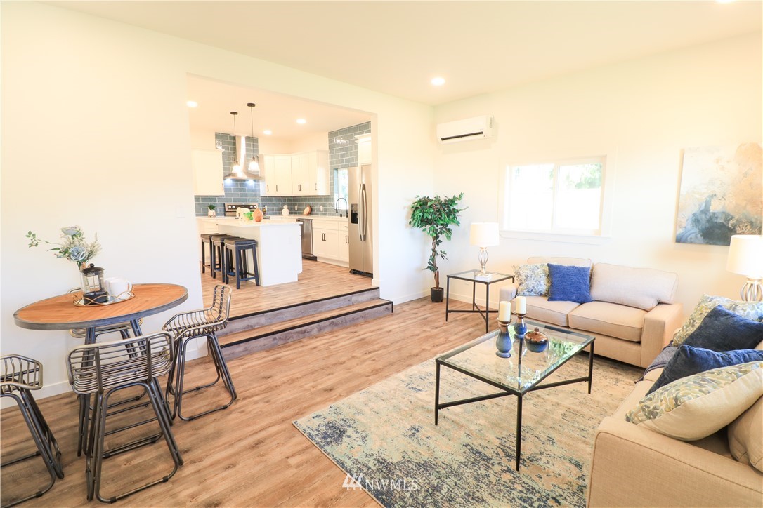 9331 Cullens Road Southeast Yelm, WA 98597 - Photo 5 of 28 a living room with furniture and a dining table with kitchen view