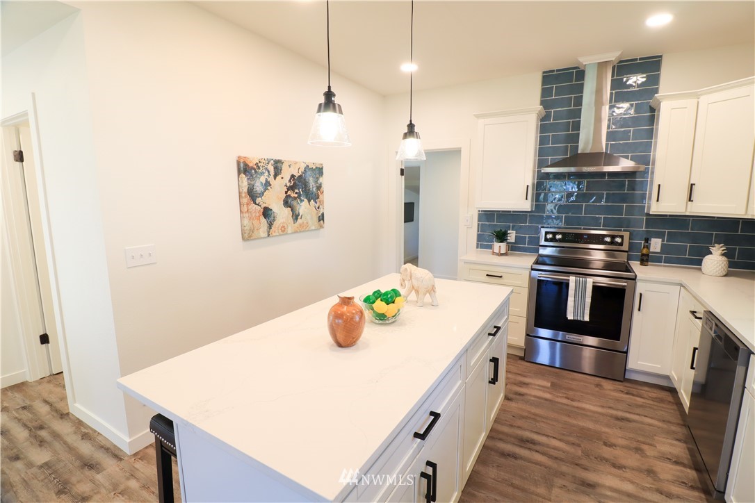9331 Cullens Road Southeast Yelm, WA 98597 - Photo 10 of 28 a kitchen with kitchen island a stove a sink and a refrigerator