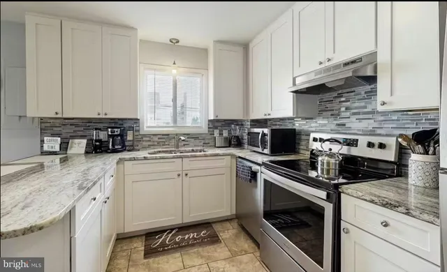 a kitchen with stainless steel appliances granite countertop a stove a sink and a granite counter tops