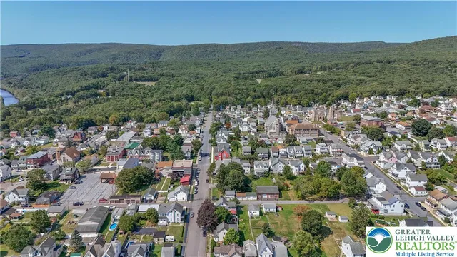 an aerial view of residential houses with outdoor space and trees