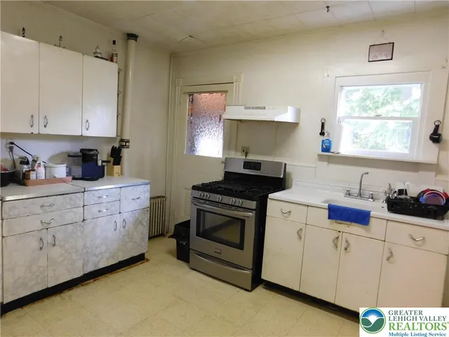 a kitchen with white cabinets and white appliances
