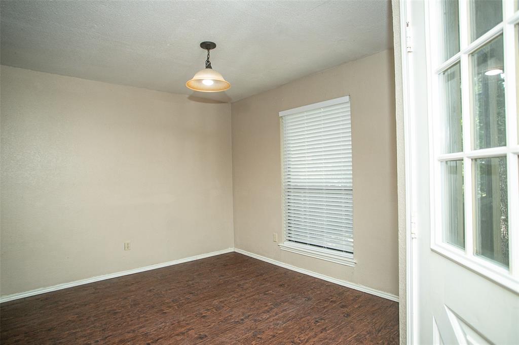 2019 West Nathan Lowe Road Arlington, TX 76017 - Photo 8 of 21 Spacious interior featuring wood-finish flooring, two window openings with blinds, a tray ceiling, and a ceiling fan with integrated lighting