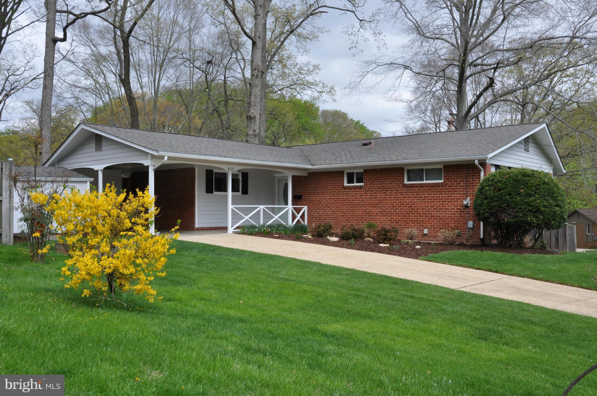 8621 Victoria Road Springfield, VA 22151 - Photo 1 of 27 a front view of a house with a garden and yard