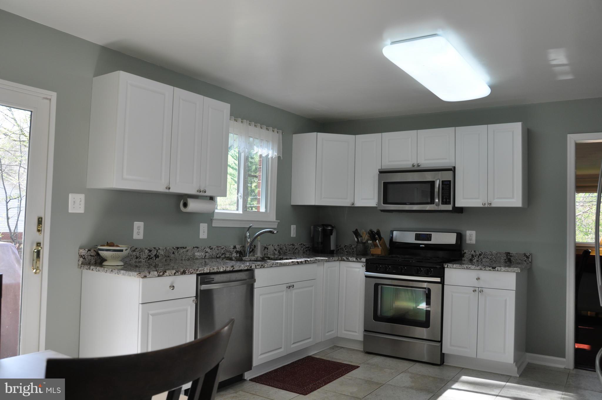 8621 Victoria Road Springfield, VA 22151 - Photo 7 of 27 a kitchen with white cabinets stainless steel appliances and sink