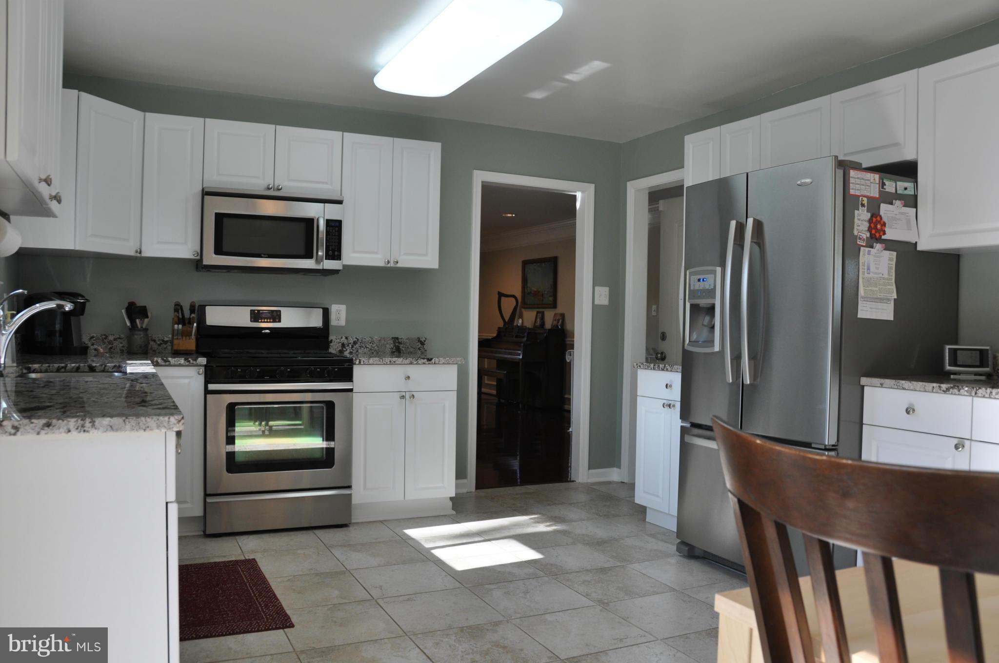8621 Victoria Road Springfield, VA 22151 - Photo 8 of 27 a kitchen with stainless steel appliances granite countertop a refrigerator and a stove top oven