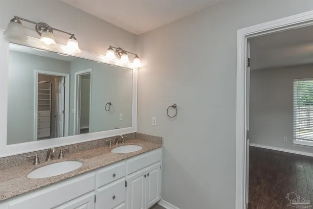 a bathroom with a granite countertop sink double and mirror