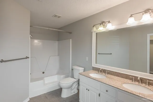 a bathroom with a granite countertop sink a toilet and bathtub