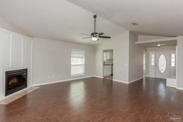 a view of an empty room with a fireplace and a window