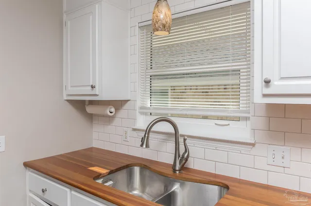 a kitchen with granite countertop a sink a stove and cabinets